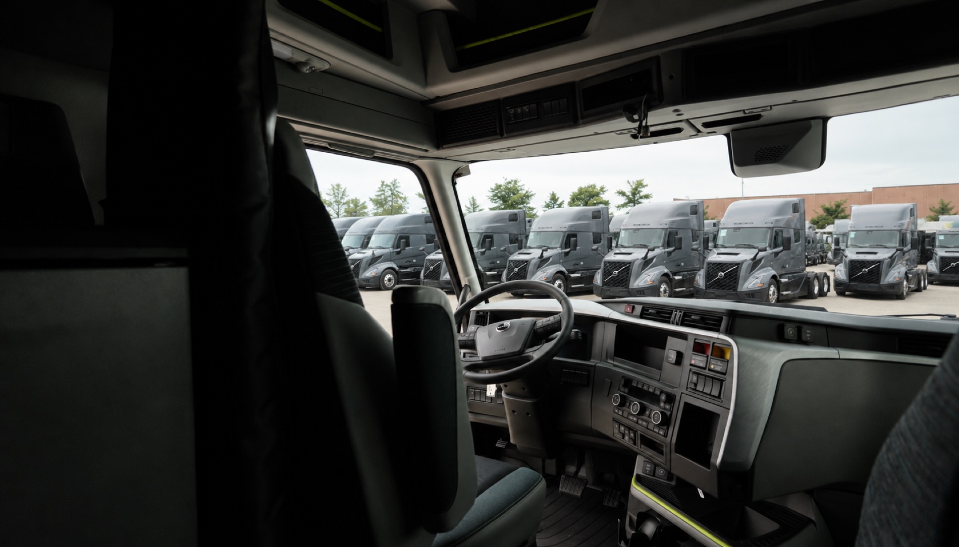 Windshield view from the cab over a yard full of new Volvos