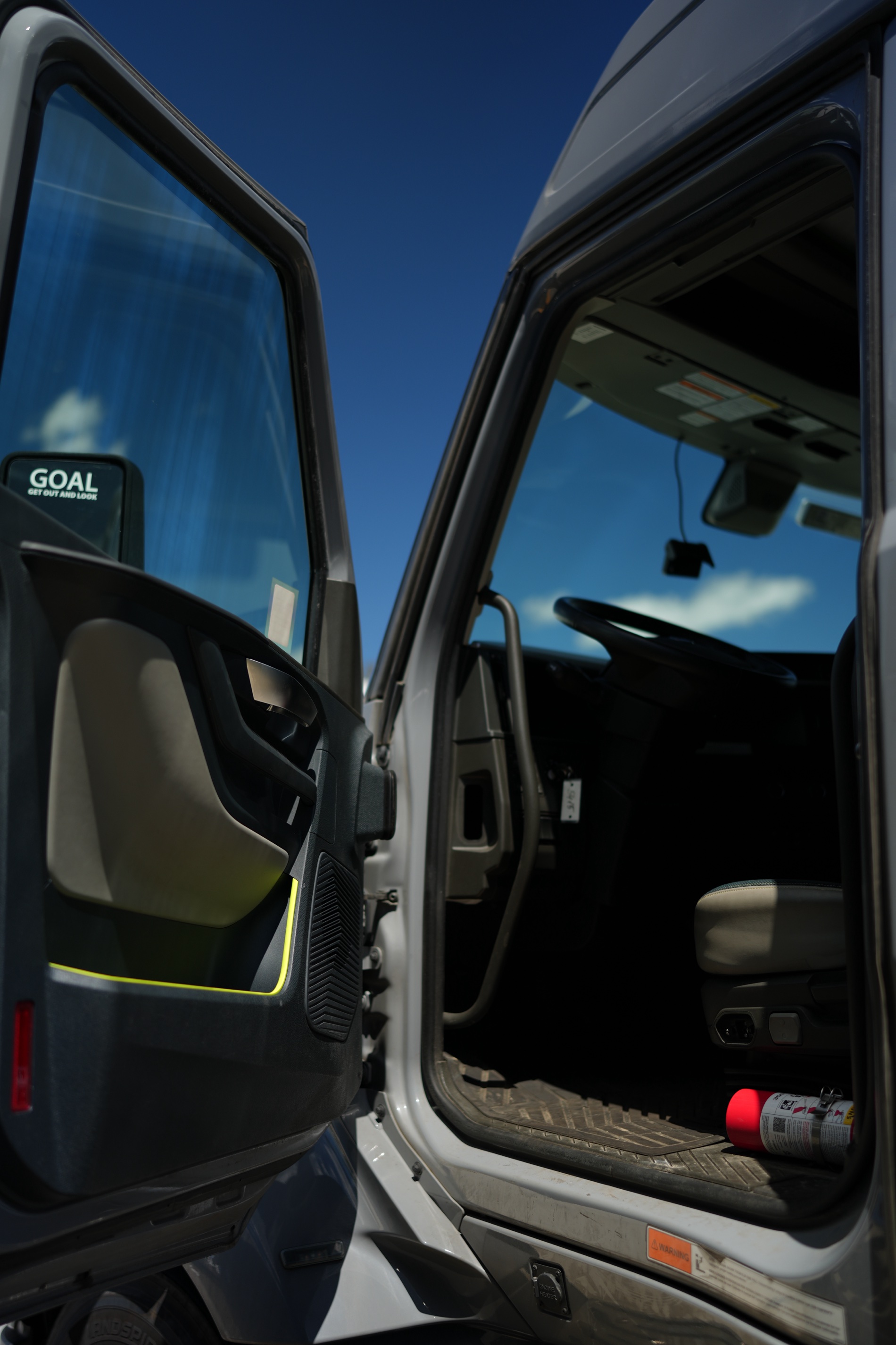 Open driver door of a brand-new Volvo VNL against the sky