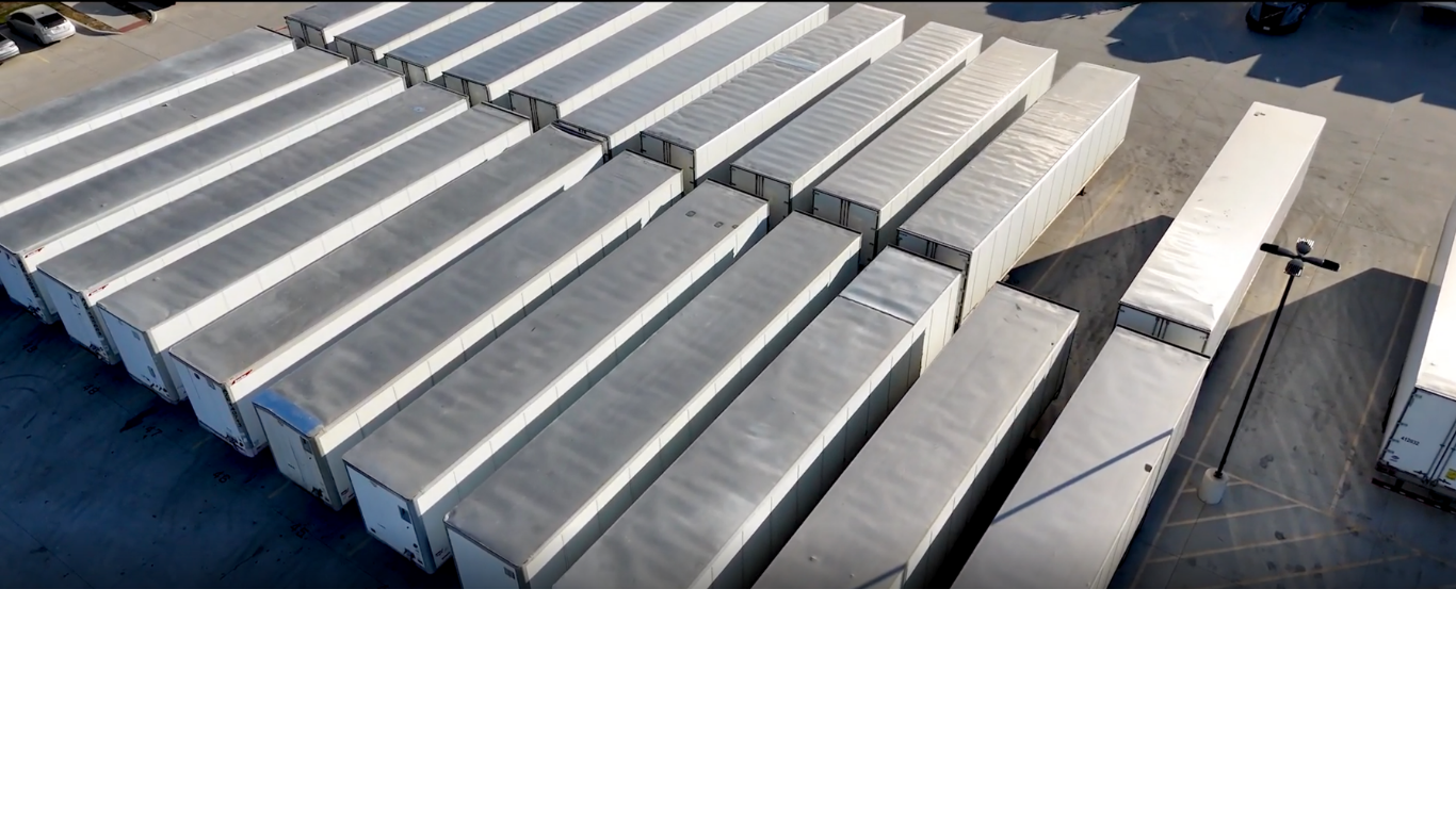 Top-down aerial of trailers and tractors at the yard